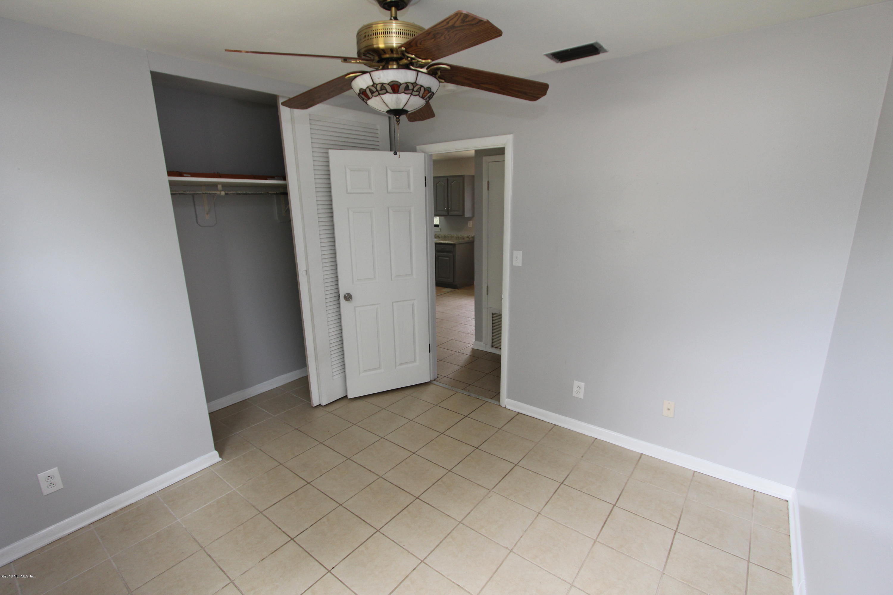 10610 Dodd Road Jacksonville, FL 32218 - Photo 11 of 24 an empty room with a empty space and a ceiling fan
