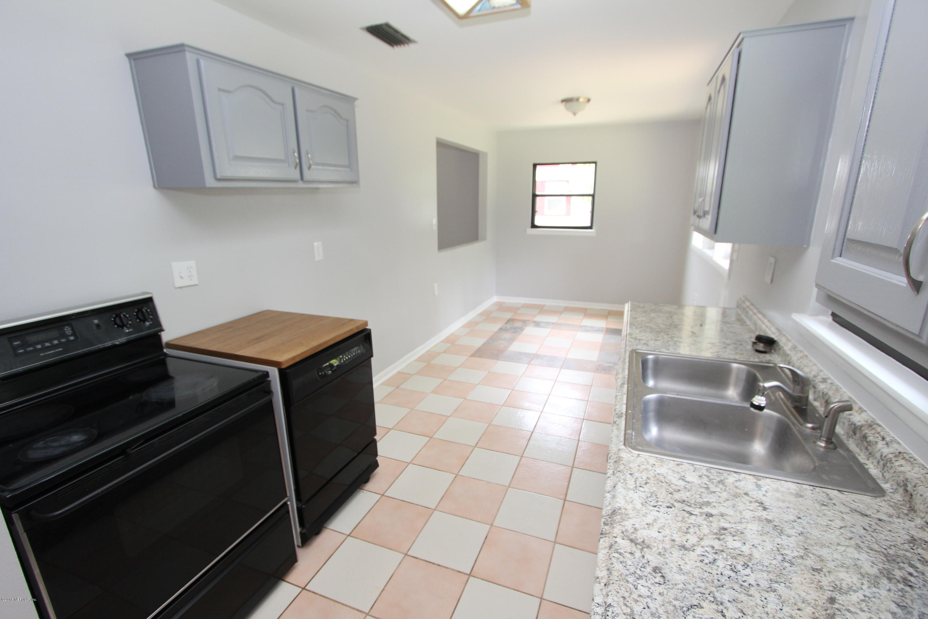 10610 Dodd Road Jacksonville, FL 32218 - Photo 6 of 24 a kitchen with granite countertop a stove a sink and a microwave