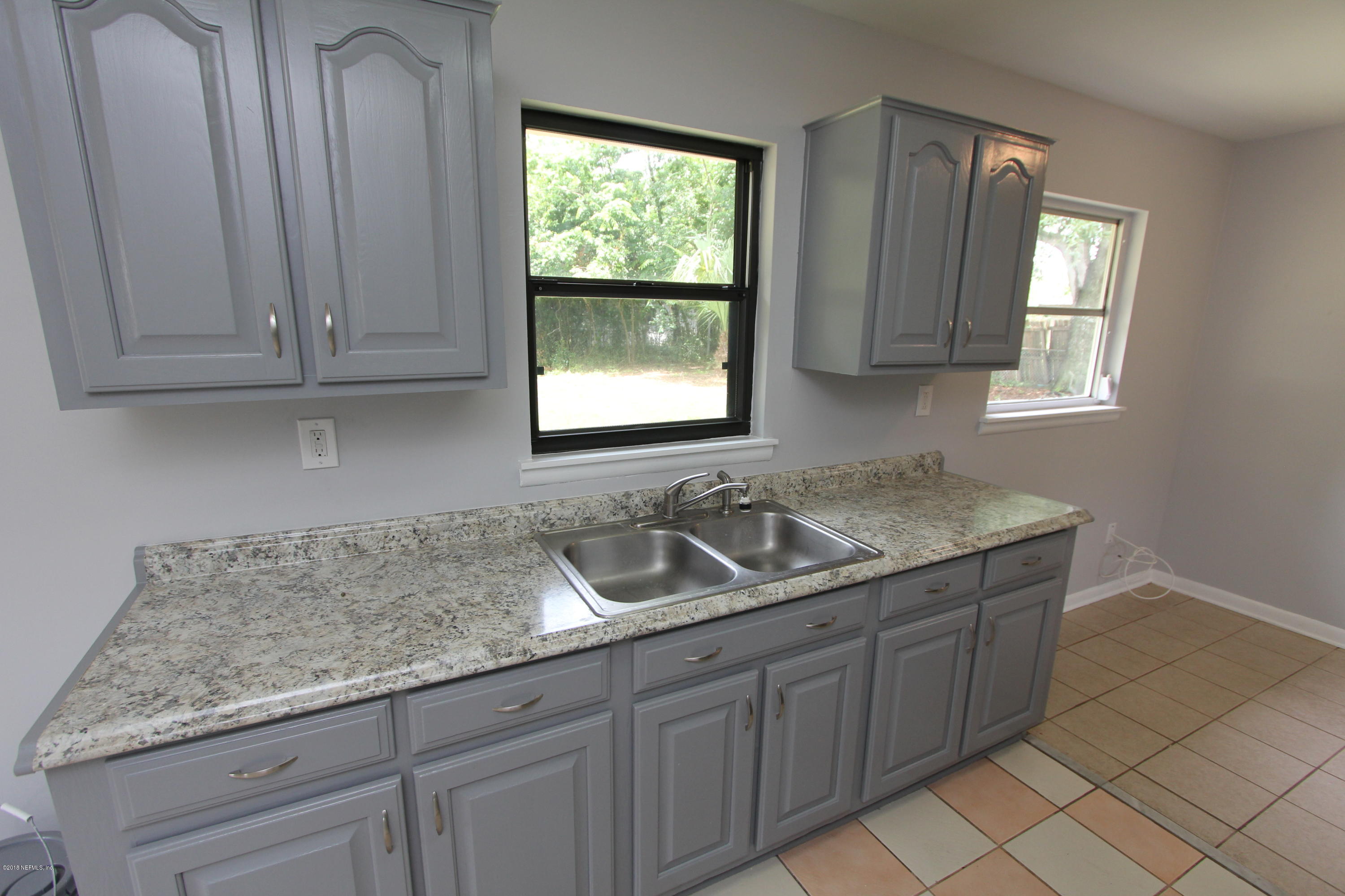 10610 Dodd Road Jacksonville, FL 32218 - Photo 7 of 24 a kitchen with granite countertop cabinets sink and window