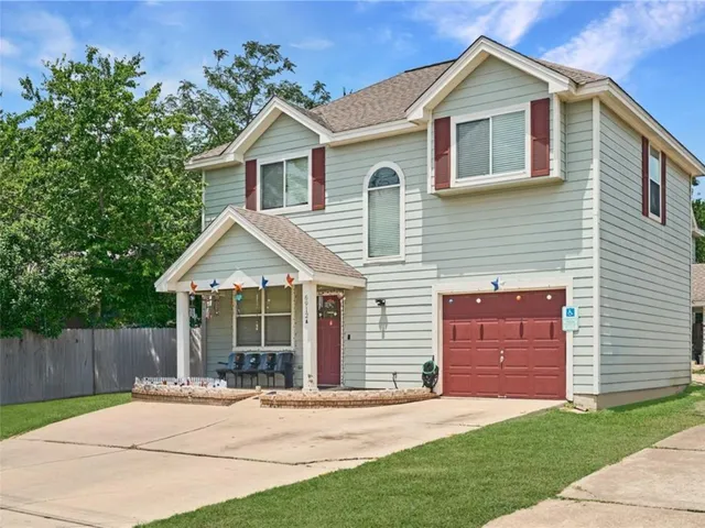 a view of a house with a yard and large tree