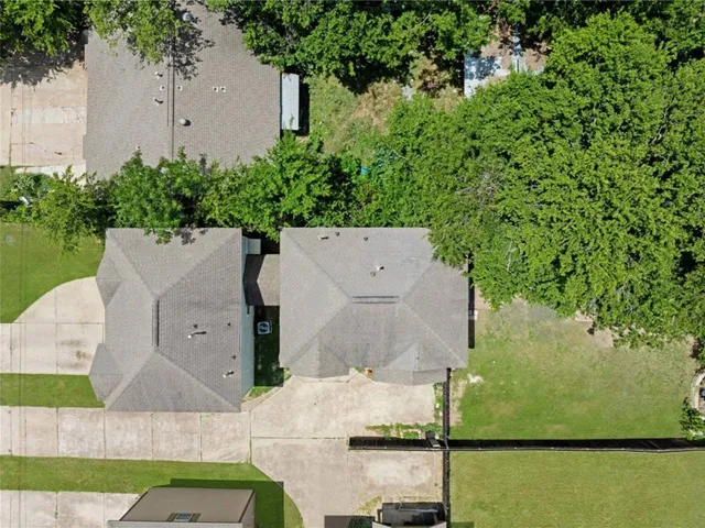 an aerial view of a house with a yard and large tree