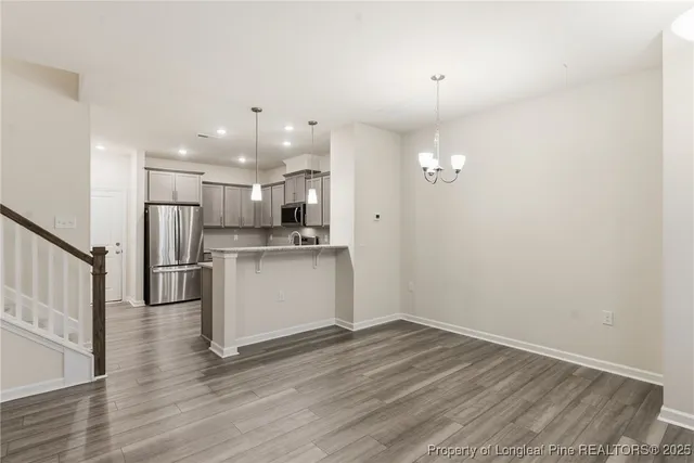 a view of kitchen with granite countertop cabinets and refrigerator