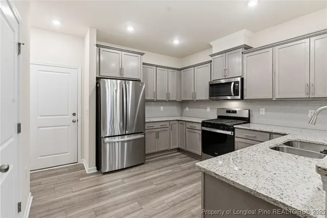 a kitchen with granite countertop a refrigerator stove and microwave