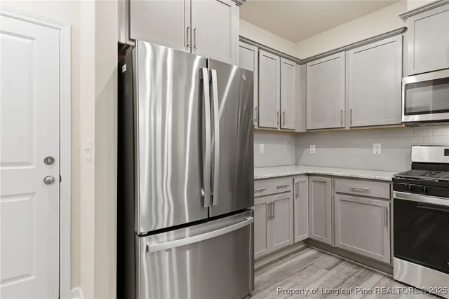 a kitchen with stainless steel appliances white cabinets and a refrigerator
