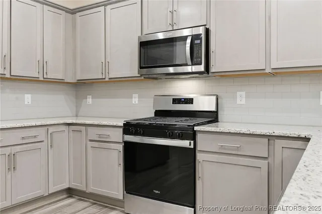 a kitchen with stainless steel appliances granite countertop white cabinets a sink and dishwasher