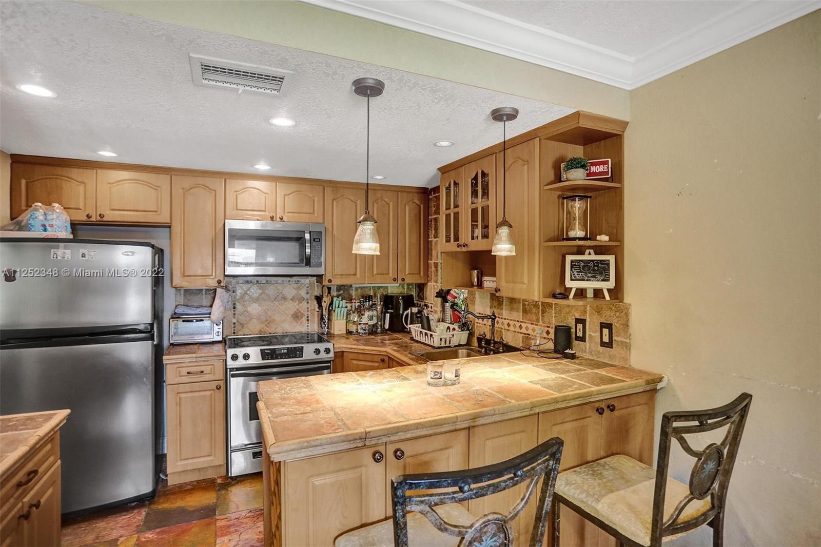 5930 Southwest 47th Street Miami, FL 33155 - Photo 25 of 43 a kitchen with kitchen island a counter top space appliances and cabinets