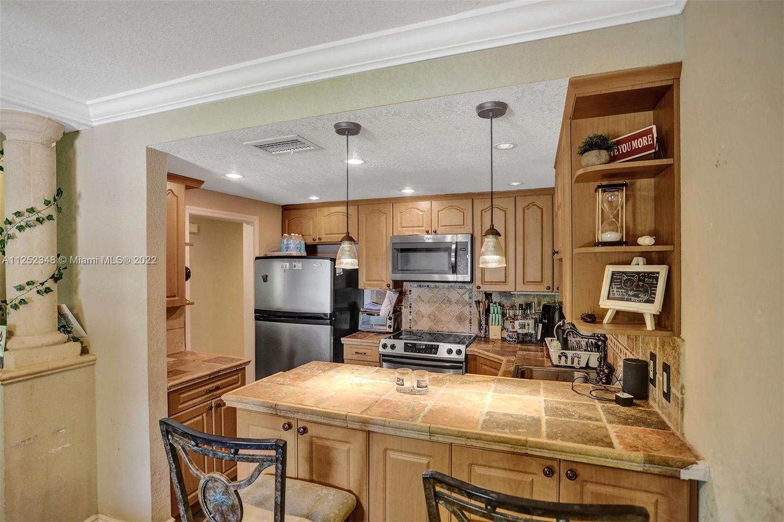 5930 Southwest 47th Street Miami, FL 33155 - Photo 27 of 43 a kitchen with kitchen island a stove a sink and a refrigerator