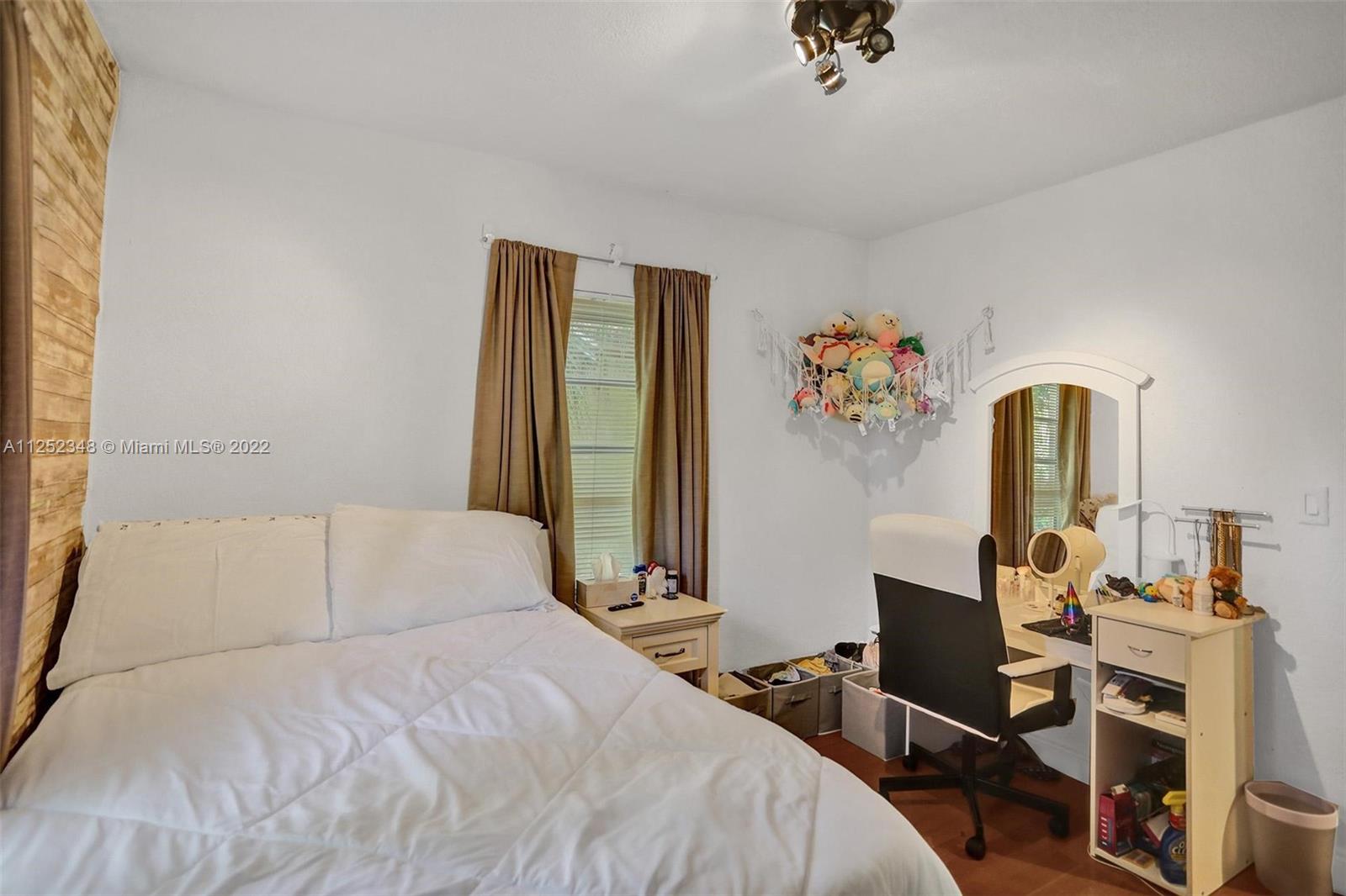 5930 Southwest 47th Street Miami, FL 33155 - Photo 39 of 43 a bedroom with a bed and a chandelier