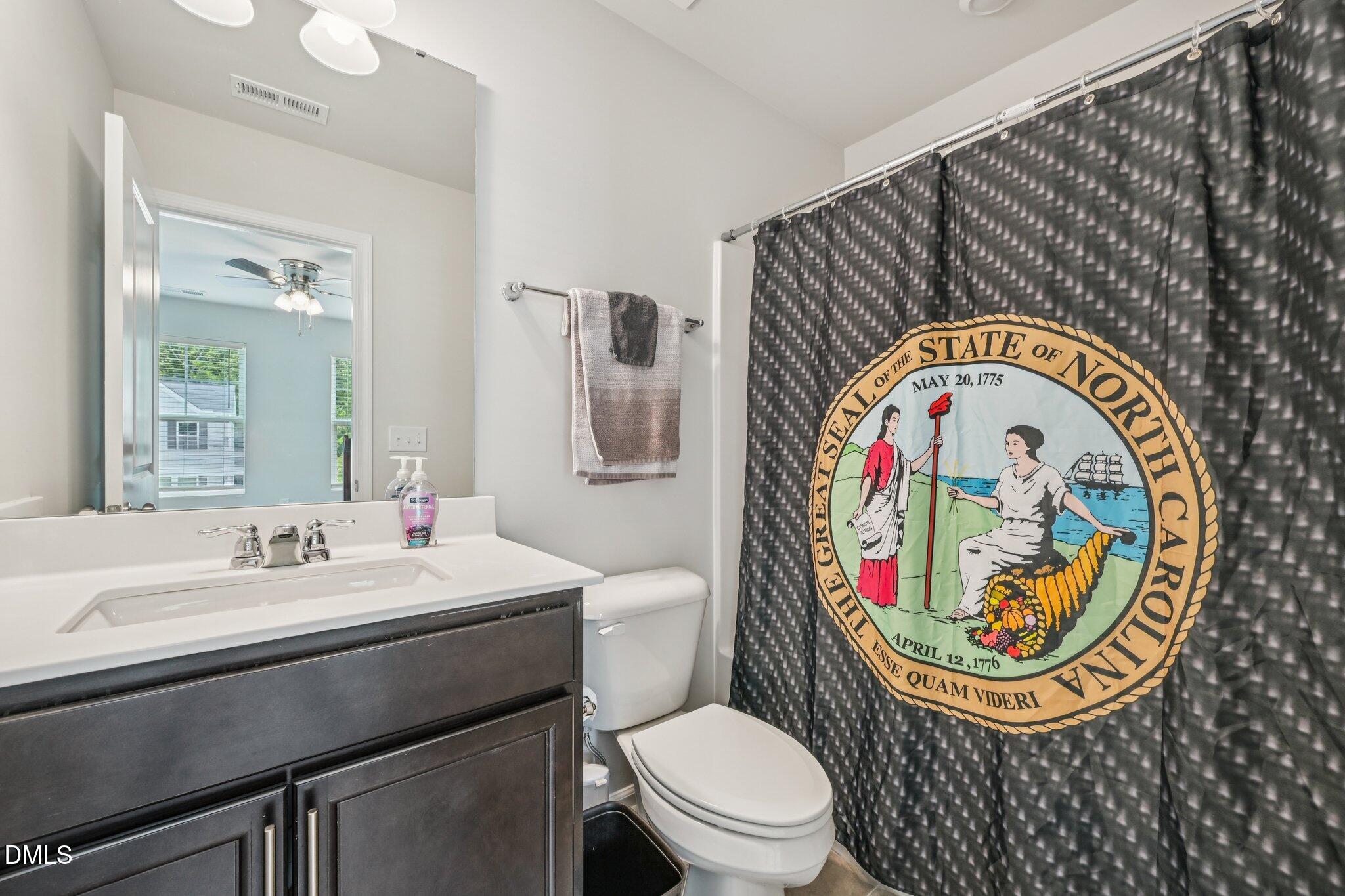 5348 Arkose Drive Raleigh, NC 27610 - Photo 18 of 21 a bathroom with a toilet a sink and a mirror