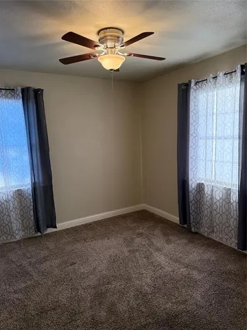 an empty room with a chandelier fan