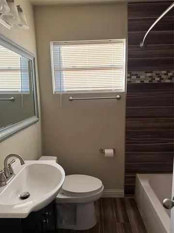 a bathroom with a sink a toilet and bathtub