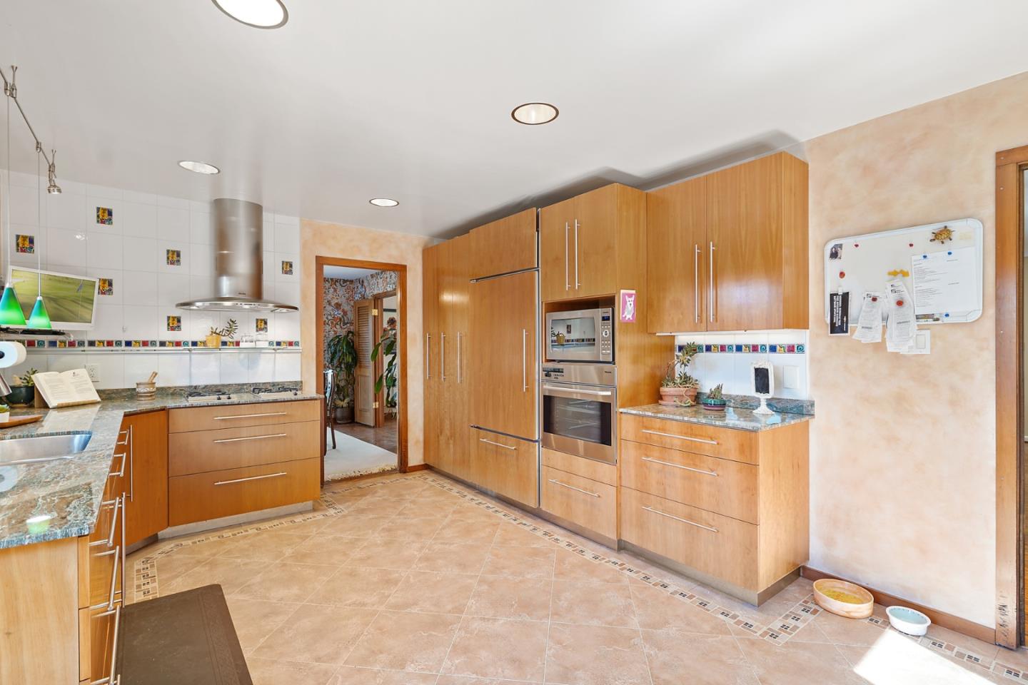 732 Knoll Drive San Carlos, CA 94070 - Photo 10 of 55 a kitchen with stainless steel appliances kitchen island granite countertop a refrigerator and a stove top oven