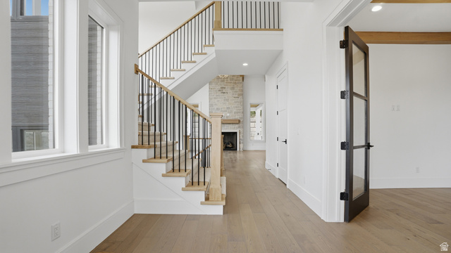 1682 North 1950 W Street, Unit 9 Provo, UT 84604 - Photo 11 of 84 Foyer featuring light wood-finish flooring, a contemporary staircase with black metal balusters and a wood handrail, and white trim