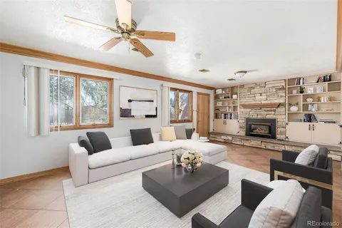a living room with furniture fireplace and a large window