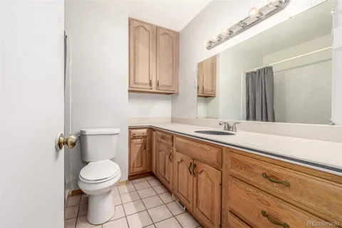 a bathroom with a granite countertop toilet sink and mirror