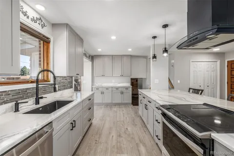 a kitchen with a sink stove top oven and cabinets