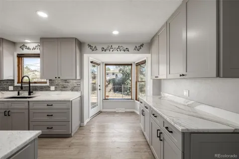a bathroom with a granite countertop sink and a large mirror