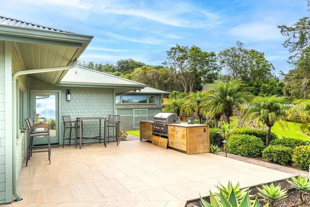 a patio with a table and chairs and potted plants
