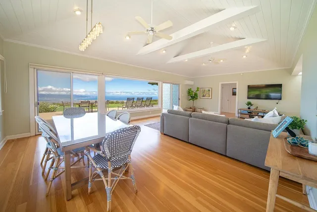a view of a dining room with furniture a kitchen and chandelier