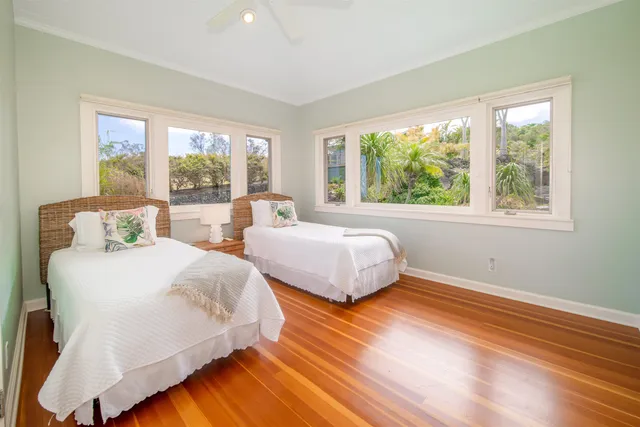 a bedroom with two beds and a large window