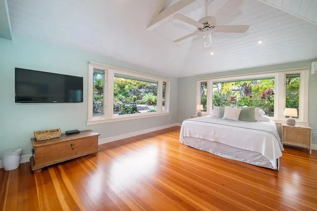 a spacious bedroom with a bed and a flat screen tv