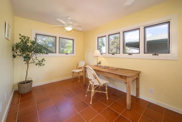 a dining room with furniture and a potted plant
