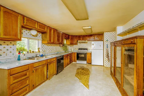 a large kitchen with stainless steel appliances kitchen island granite countertop a sink and cabinets