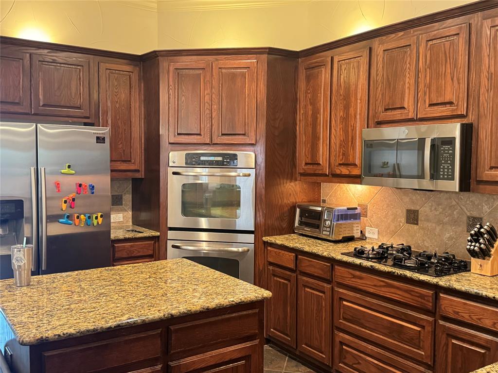 5412 Bentrose Drive McKinney, TX 75070 - Photo 5 of 24 a kitchen with stainless steel appliances granite countertop a refrigerator and stove