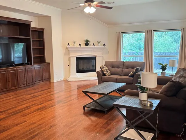 a living room with furniture a fireplace and a flat screen tv