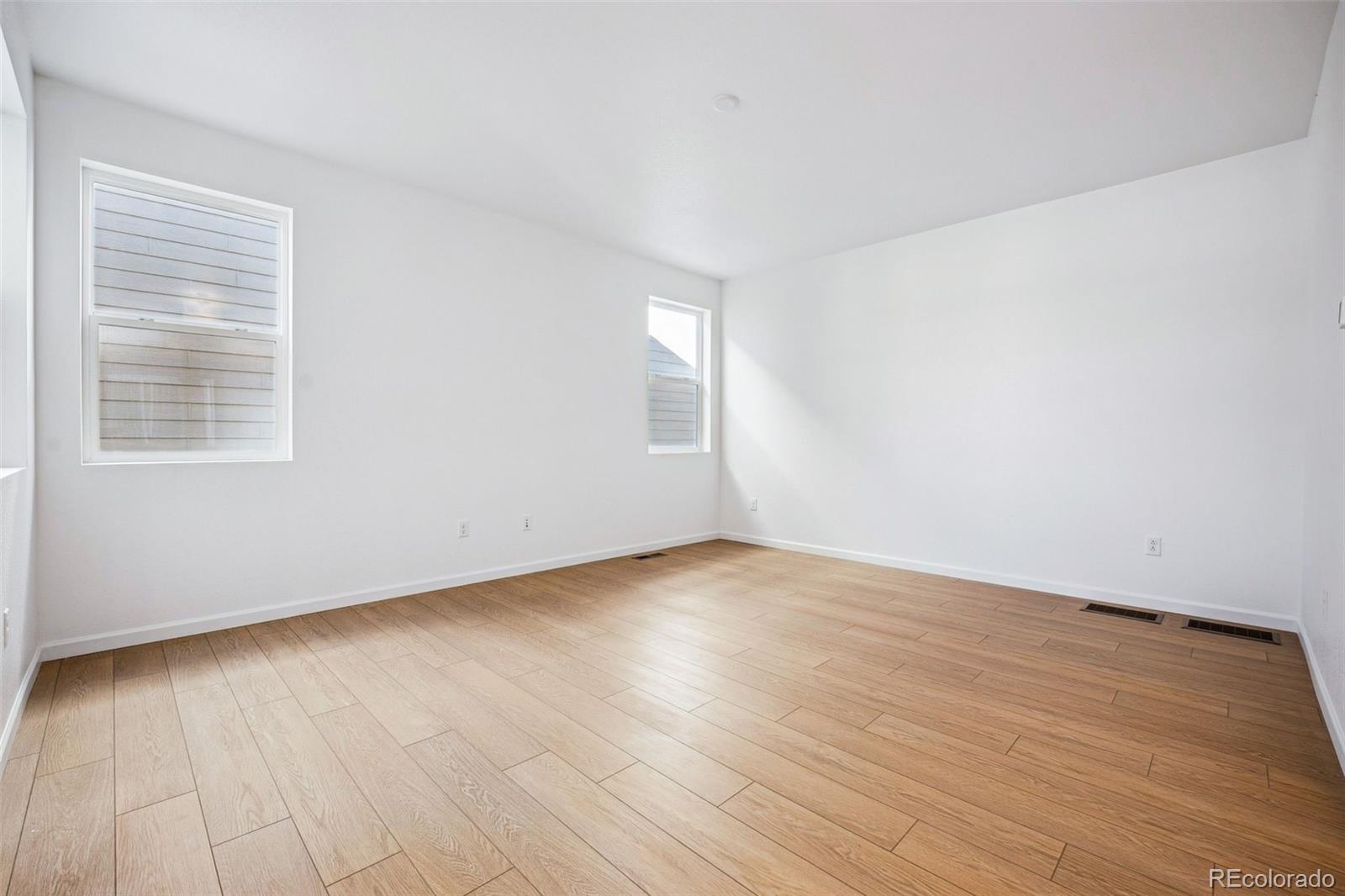 2068 Chambers Road Brighton, CO 80601 - Photo 7 of 27 a view of an empty room with wooden floor and a window