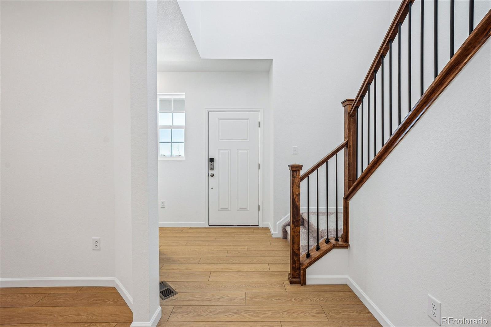2068 Chambers Road Brighton, CO 80601 - Photo 10 of 27 a view of a hallway with wooden floor and staircase