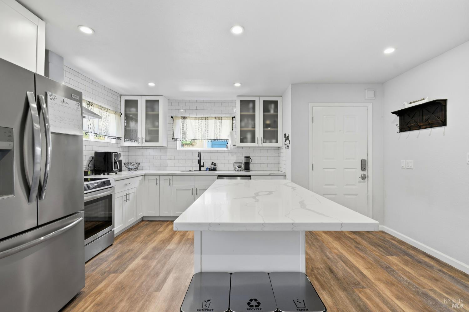 5193 Firestone Place Santa Rosa, CA 95409 - Photo 13 of 35 Fully remodeled kitchen featuring a quartz island, updated cabinetry, subway tile backsplash, and stainless steel appliances.