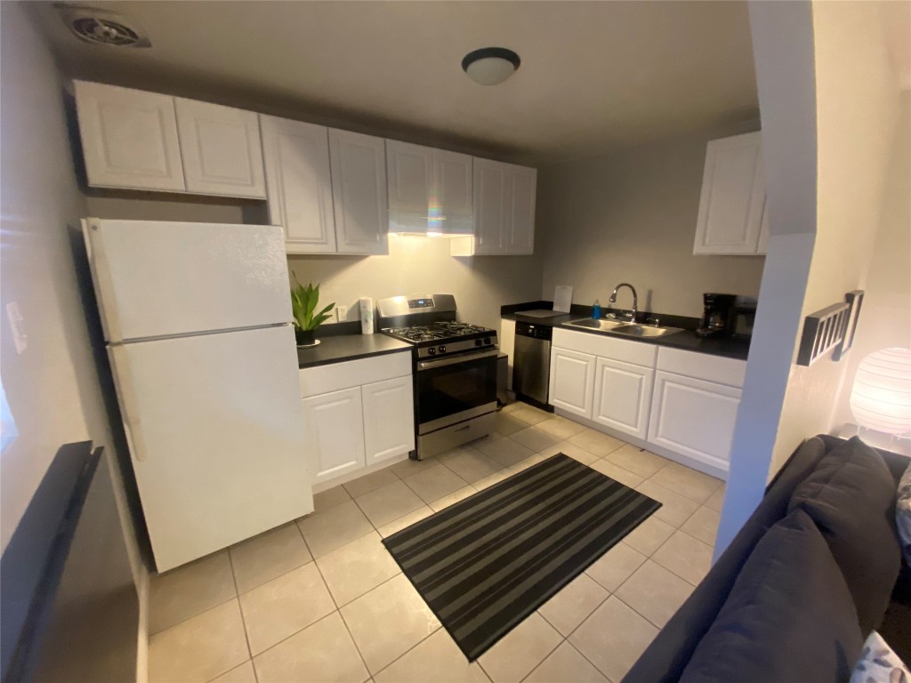 4202 Stanford Street, Unit 5 Houston, TX 77006 - Photo 5 of 7 a kitchen with granite countertop a refrigerator stove top oven and sink