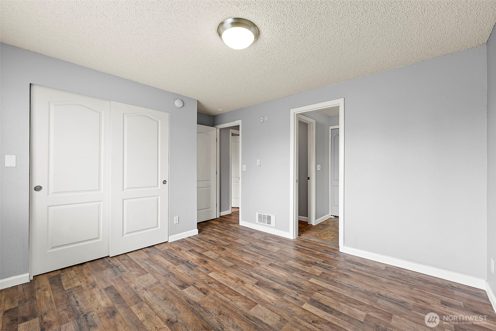10010 Golden Given Road East, Unit 4 Tacoma, WA 98445 - Photo 12 of 19 a view of an empty room with wooden floor