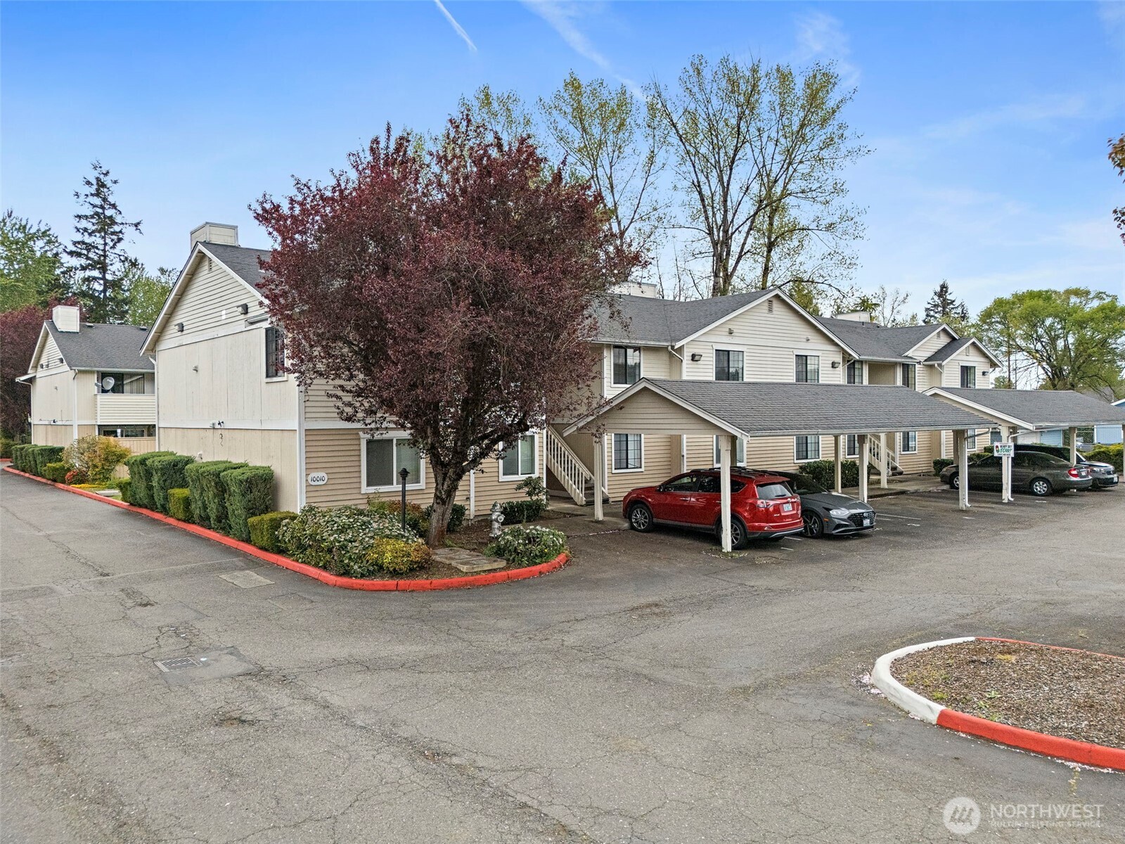 10010 Golden Given Road East, Unit 4 Tacoma, WA 98445 - Photo 17 of 19 a front view of a house with a garden and trees