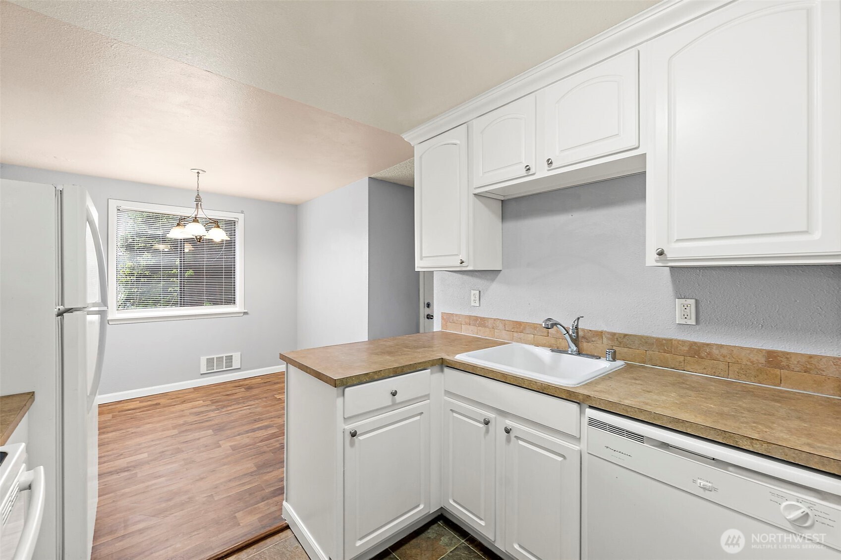 10010 Golden Given Road East, Unit 4 Tacoma, WA 98445 - Photo 2 of 19 a kitchen with granite countertop white cabinets white appliances and a sink