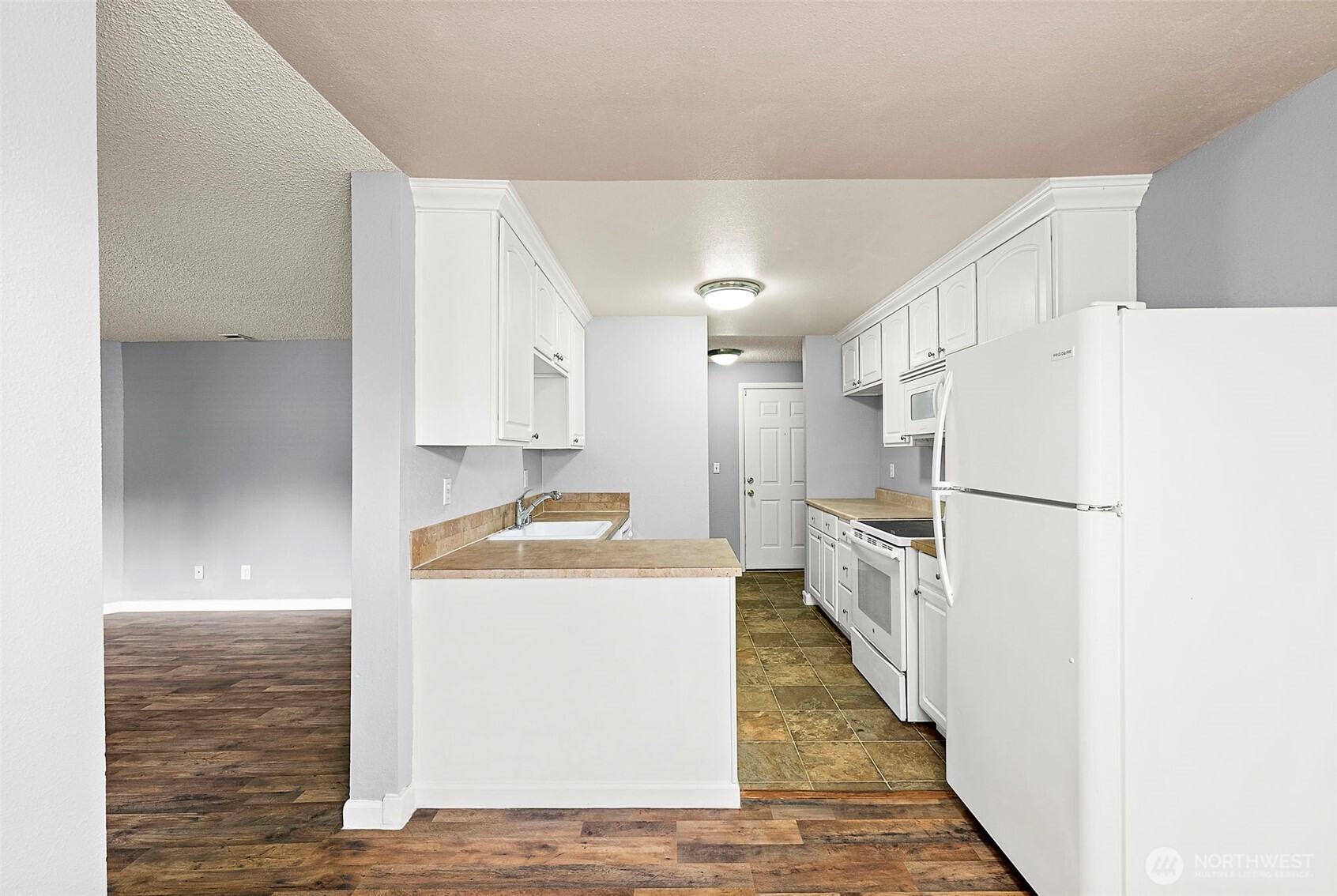 10010 Golden Given Road East, Unit 4 Tacoma, WA 98445 - Photo 4 of 19 a kitchen with a stove a refrigerator and a sink