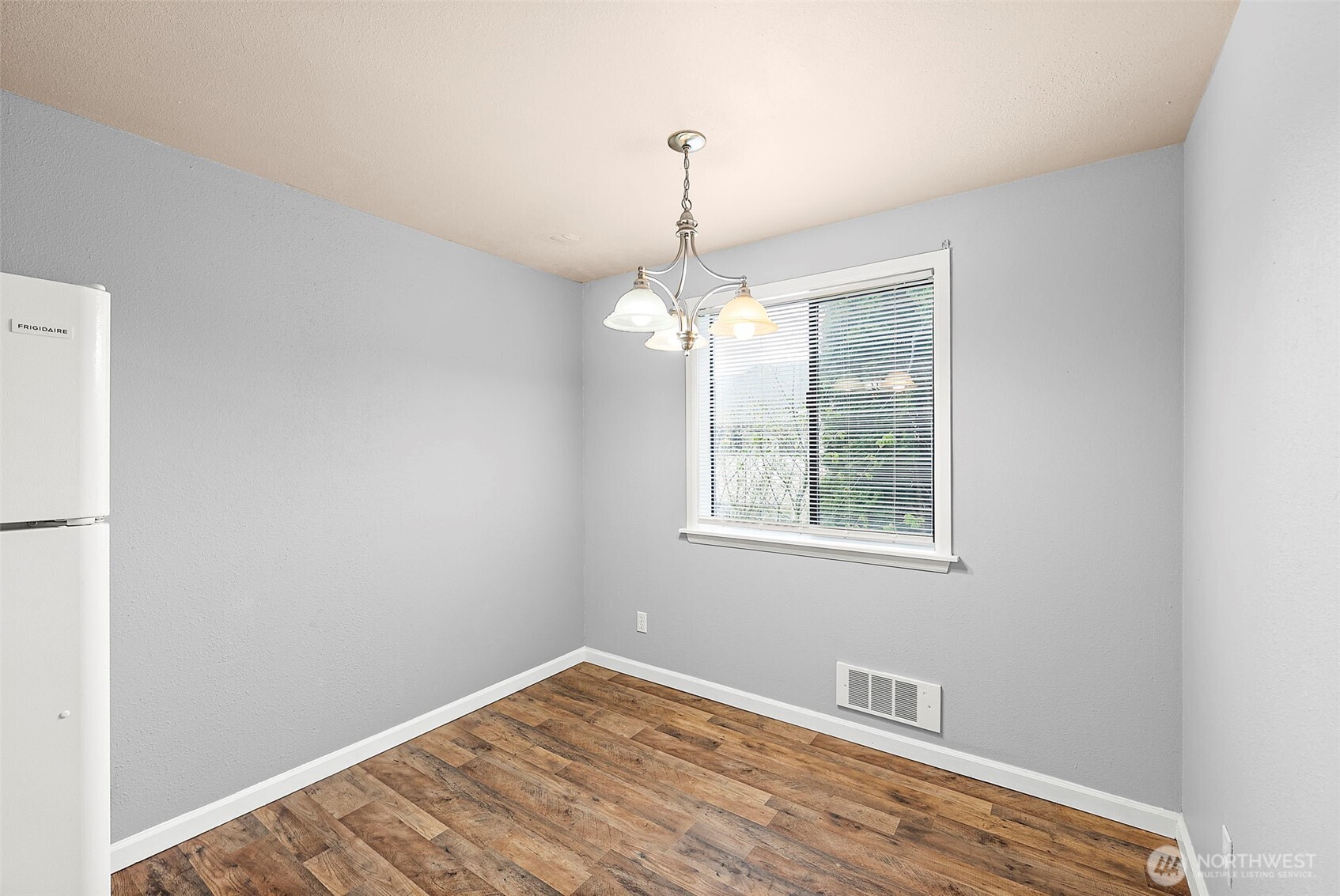 10010 Golden Given Road East, Unit 4 Tacoma, WA 98445 - Photo 5 of 19 a view of an empty room with wooden floor and a window
