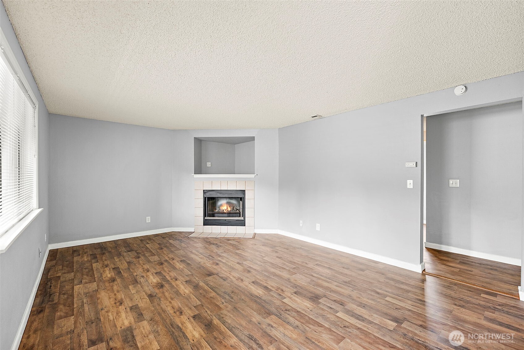 10010 Golden Given Road East, Unit 4 Tacoma, WA 98445 - Photo 6 of 19 wooden floor in an empty room with a fireplace