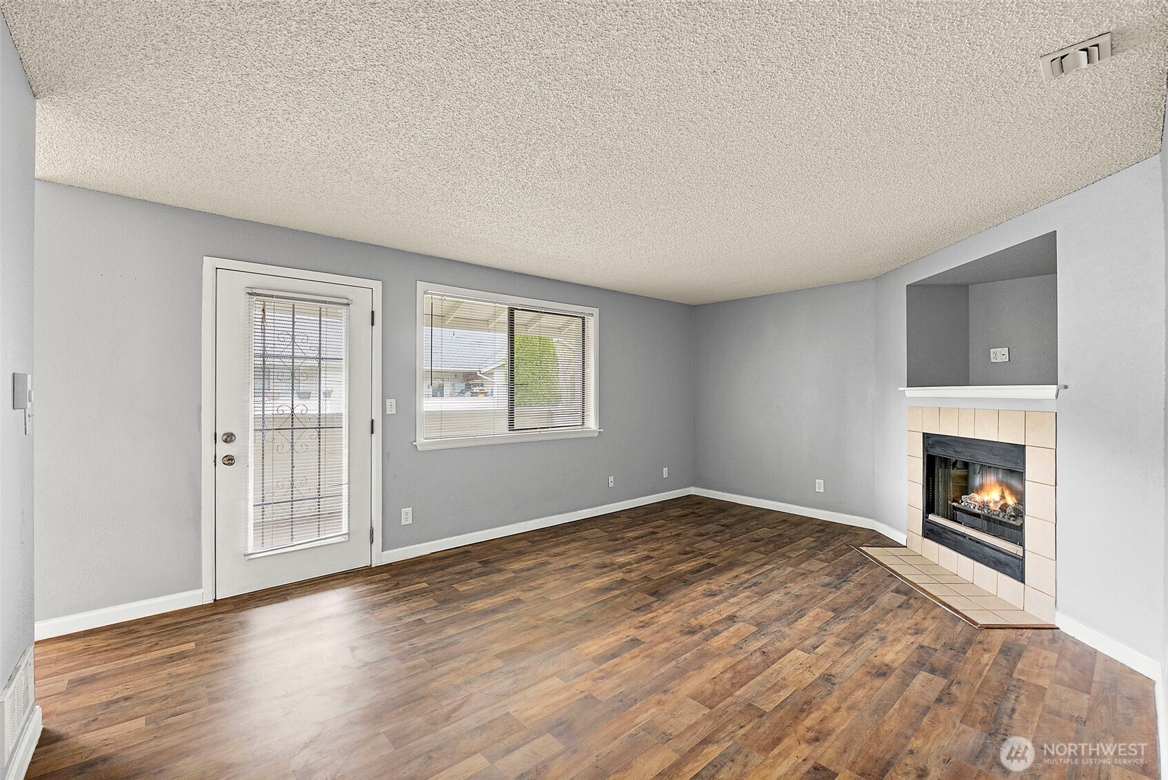 10010 Golden Given Road East, Unit 4 Tacoma, WA 98445 - Photo 8 of 19 a view of empty room with wooden floor and fireplace