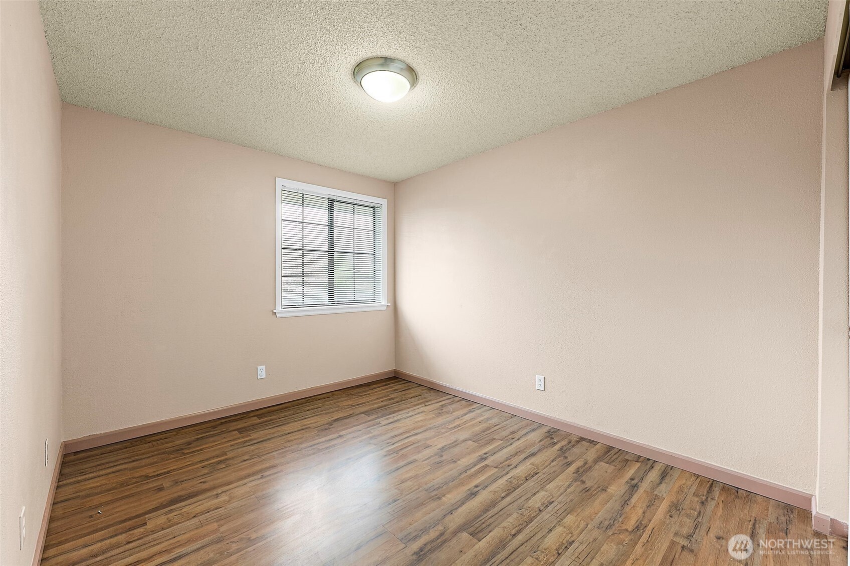 10010 Golden Given Road East, Unit 4 Tacoma, WA 98445 - Photo 10 of 19 an empty room with wooden floor and windows