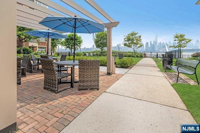 26 Ave At Port Imperial, Unit 307 West New York, NJ 07093 - Photo 22 of 25 a view of a patio with a table and chairs under an umbrella