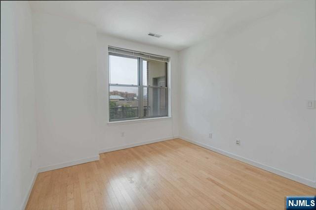 26 Ave At Port Imperial, Unit 307 West New York, NJ 07093 - Photo 6 of 25 a view of an empty room with wooden floor and a window