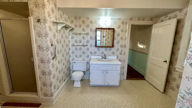 an empty room with wooden floor fireplace and windows