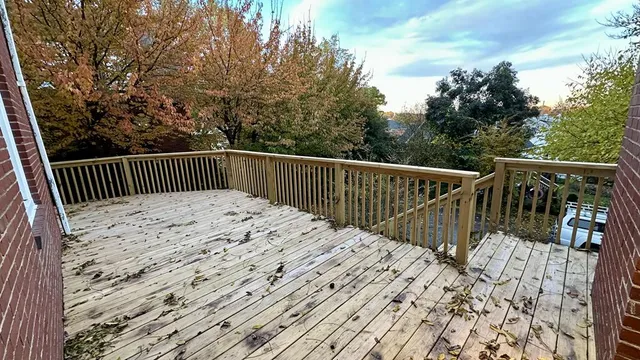a view of balcony with wooden floor and fence