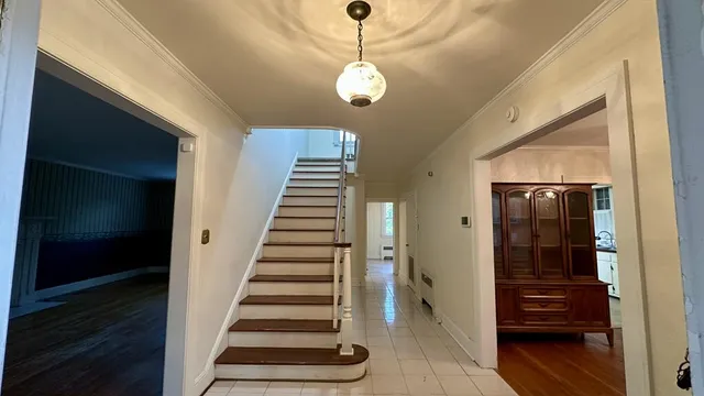 a view of a hallway with wooden floor and staircase