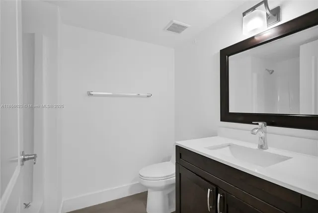 a bathroom with a sink a toilet a mirror and vanity