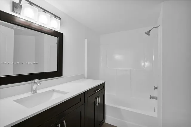 a bathroom with a bathtub sink vanity and mirror