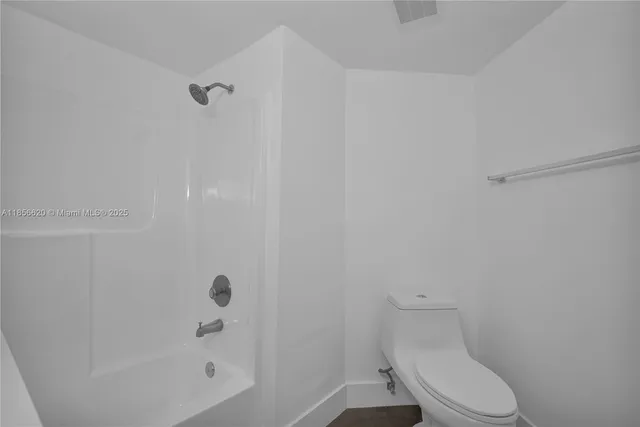 a white toilet sitting next to a bath tub