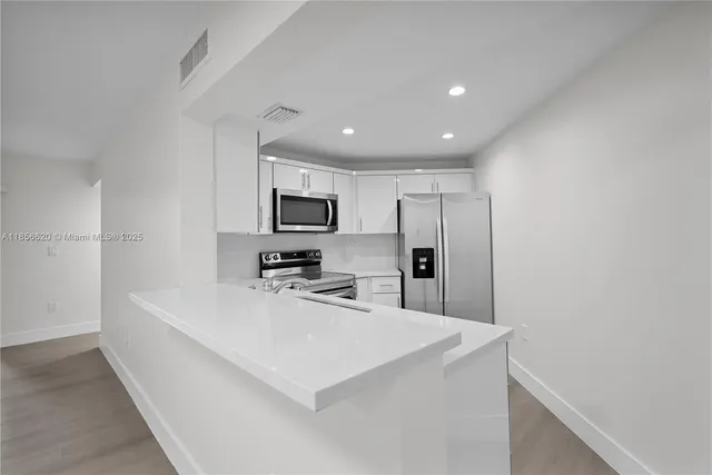 a kitchen with stainless steel appliances a refrigerator sink and microwave
